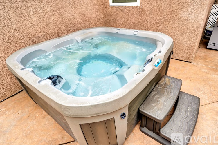 A hot tub with a blue interior is placed on a tiled floor.