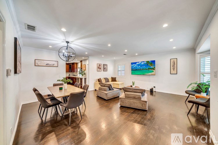 A well-lit living room with a dining table and chairs.