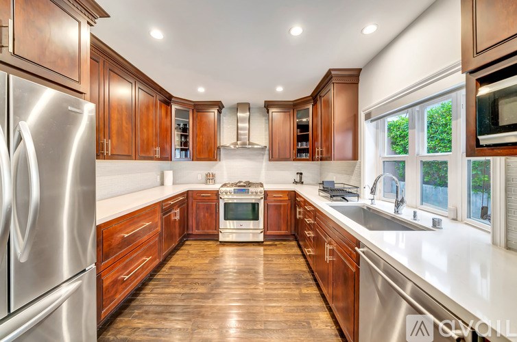 A modern kitchen with wooden cabinets and stainless steel appliances.