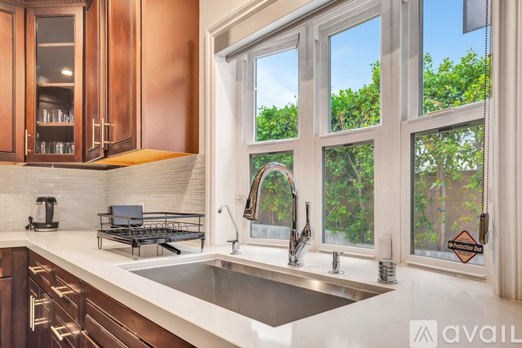 A kitchen with a sink, a window, and a coffee maker.