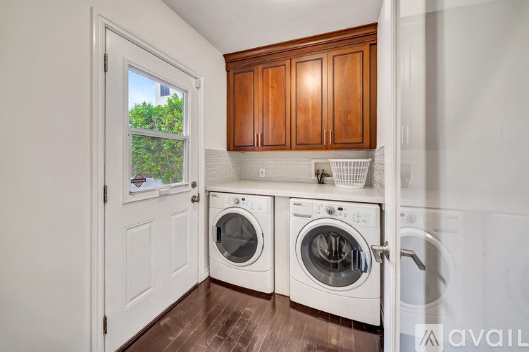 A laundry room with a view of trees outside the window.