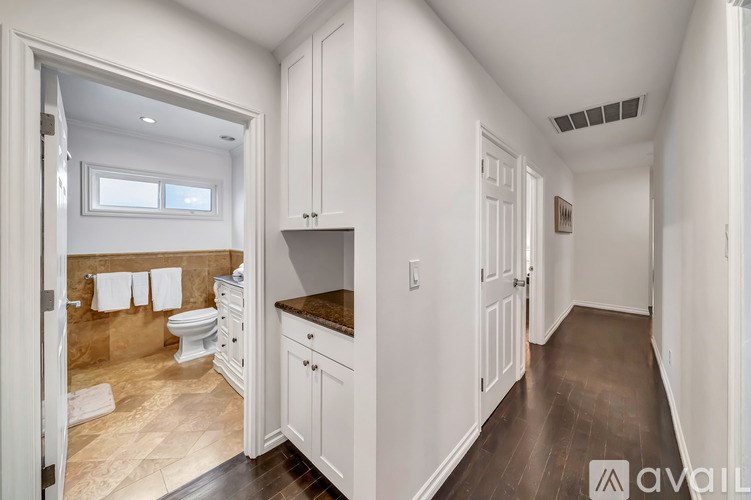 A bathroom with a toilet, sink, and a window.
