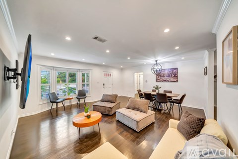 A living room with a white couch and a television on the wall.