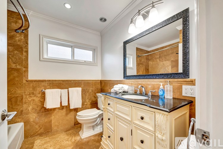 A bathroom with a toilet, sink, and mirror.
