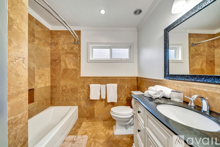 A bathroom with a tub, toilet, and sink.
