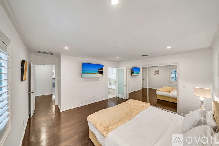 A bedroom with a large bed and a painting on the wall.