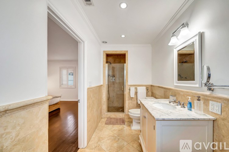 A bathroom with a marble countertop and a walk-in shower.