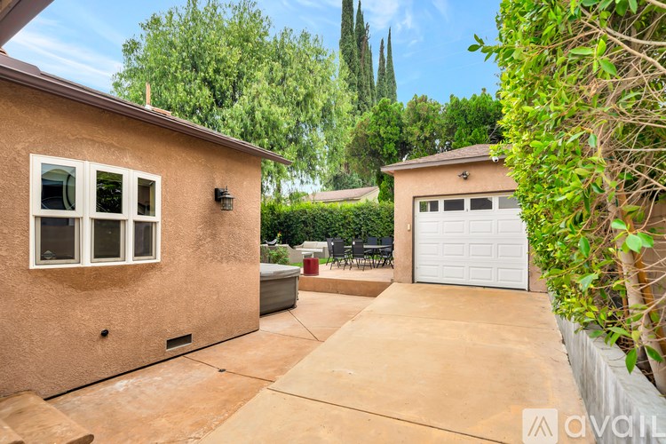 A house with a brown stucco exterior and a white garage door is for sale.