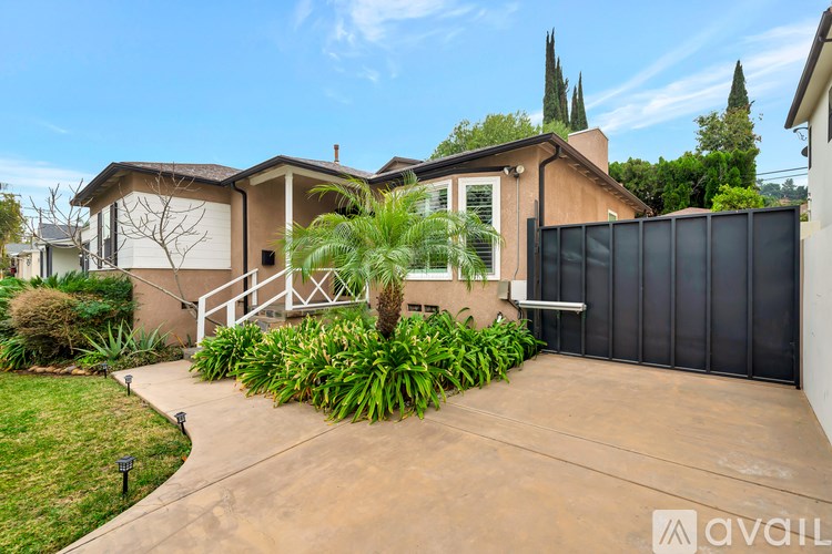 A house with a brown roof and a black fence is for sale.