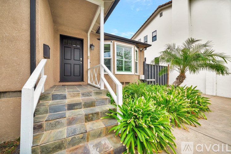 A house with a black door and a stone staircase leading to it.