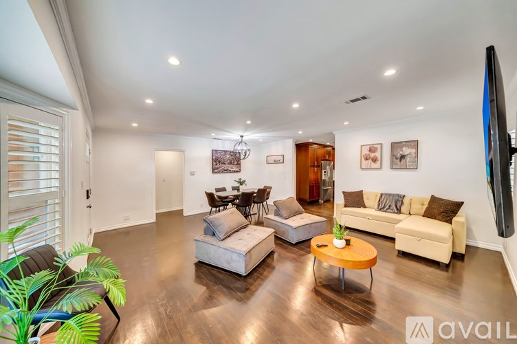 A living room with a couch, a coffee table, and a television.