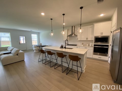 A modern kitchen with a large island and bar stools.