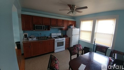 A kitchen with a refrigerator, microwave, and oven.