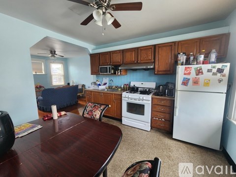 A kitchen with a white refrigerator and wooden cabinets.