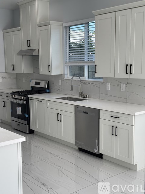 A kitchen with white cabinets and appliances.