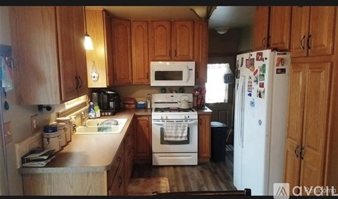 A kitchen with wooden cabinets and a white refrigerator.