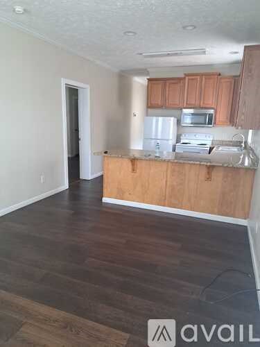 A kitchen with wooden cabinets and a white fridge.