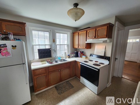 A kitchen with a white refrigerator and wooden cabinets.