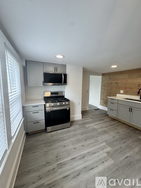A kitchen with a wooden wall and a stove top oven.