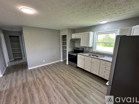 A kitchen with white cabinets and a window.
