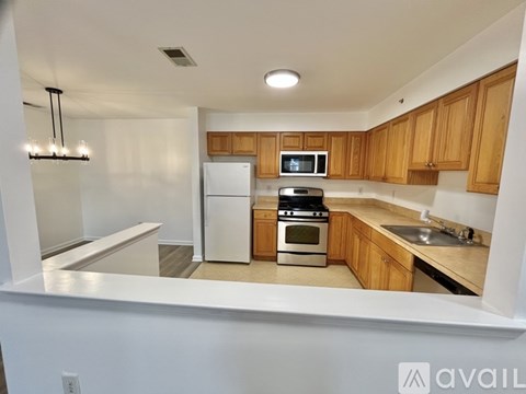 A kitchen with wooden cabinets and a white fridge.