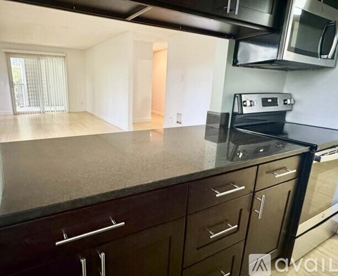A kitchen with dark brown cabinets and stainless steel appliances.