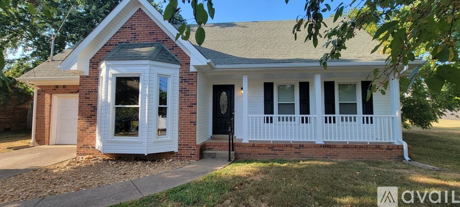 A small house with a black door and a garage door.