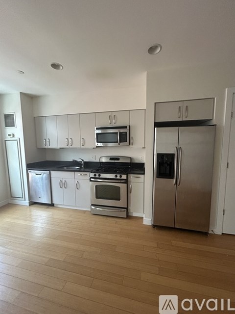 A kitchen with wooden floors and stainless steel appliances.