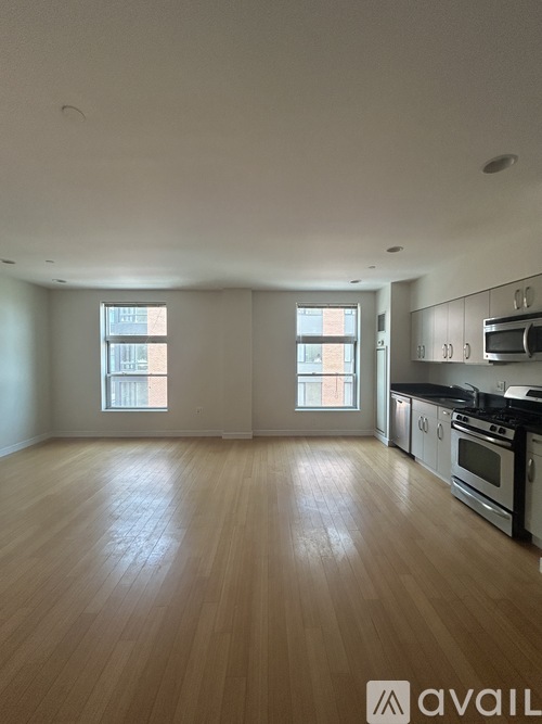 A spacious kitchen with wooden floors and stainless steel appliances.