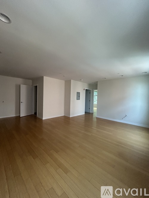 A room with wooden flooring and white walls.