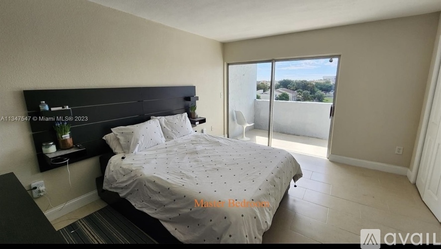 A bedroom with a large bed and a balcony overlooking the city.