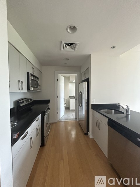 A kitchen with black countertops and white cabinets.