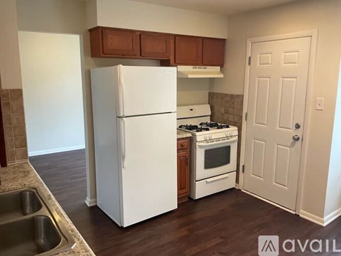 A kitchen with a white refrigerator, white stove, and white oven.
