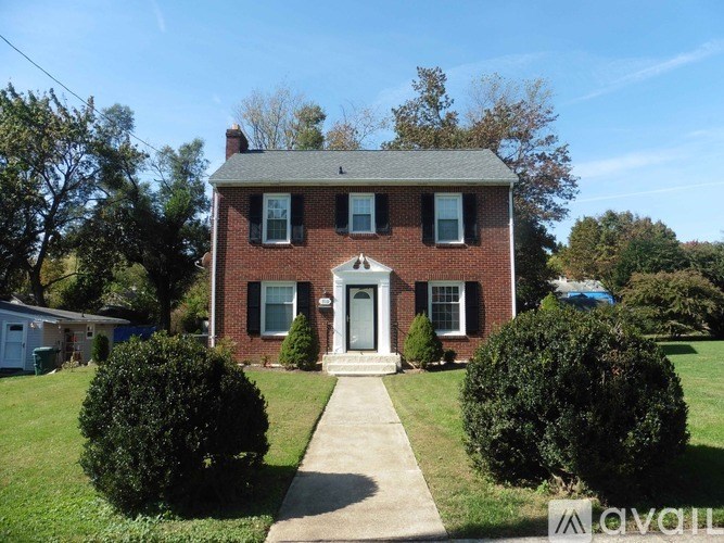 A red brick house with a white door and windows.