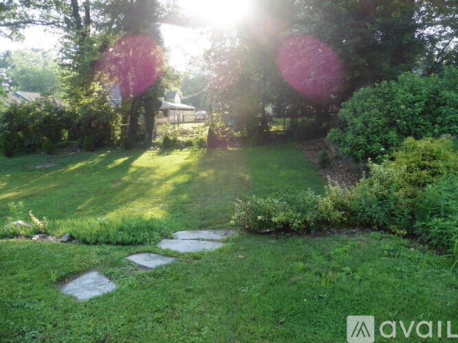 A garden with a stone path and green grass.
