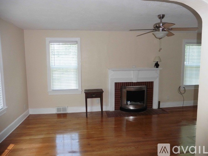 A room with a fireplace and a fan.
