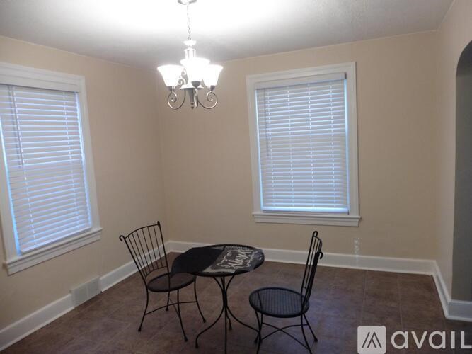 A dining room with a table and chairs.
