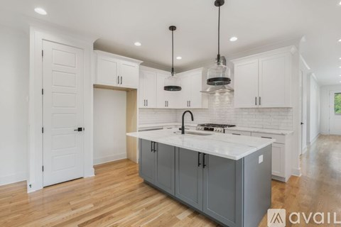 A modern kitchen with a white countertop and grey cabinets.