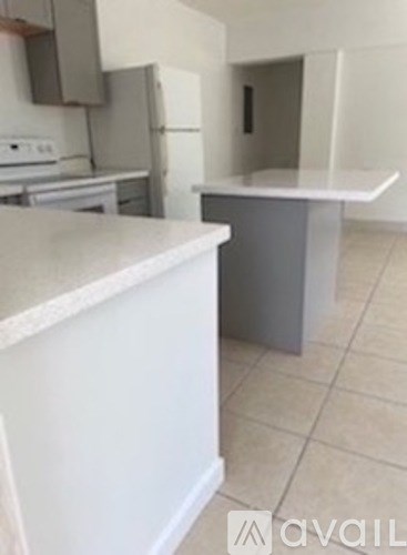 A kitchen with a white counter top and a grey counter top.
