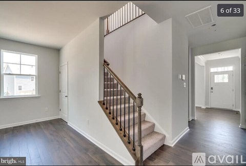 A spacious room with a staircase leading to the upper floor.