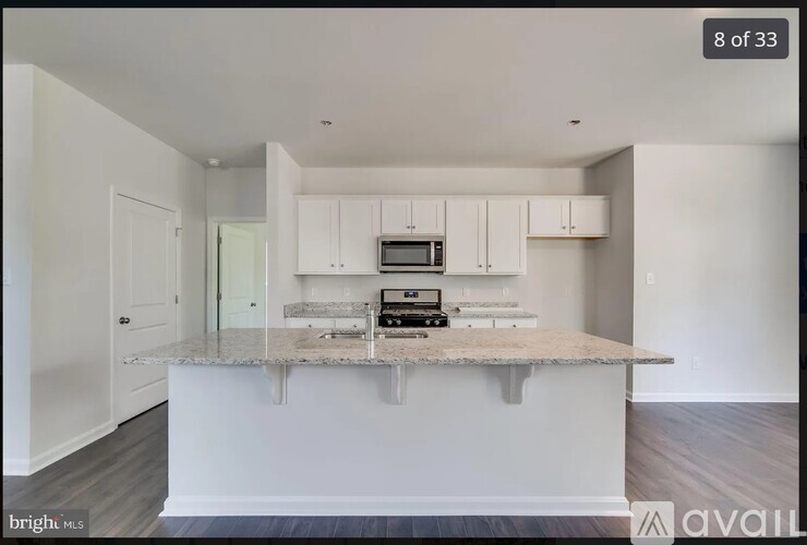 A kitchen with white cabinets and a granite countertop.