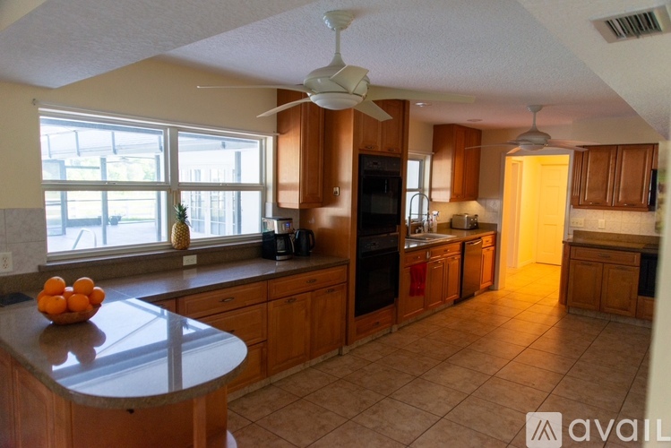 A kitchen with wooden cabinets and a black refrigerator.