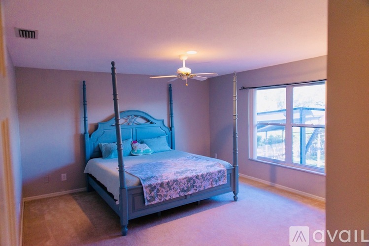A bedroom with a four poster bed and a window.