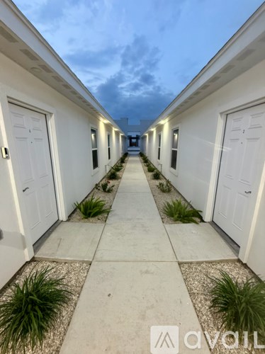A row of white houses with a cloudy sky above them.