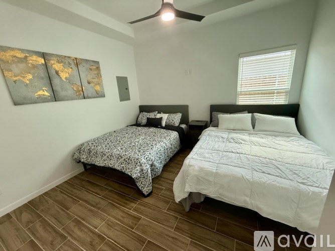 A bedroom with two beds and a ceiling fan.