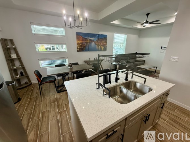 A kitchen with a sink and a dining table.