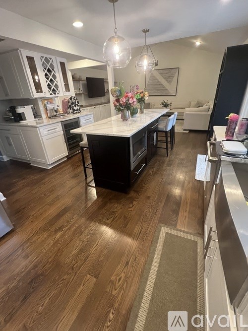 A kitchen with wooden floors and a white island.