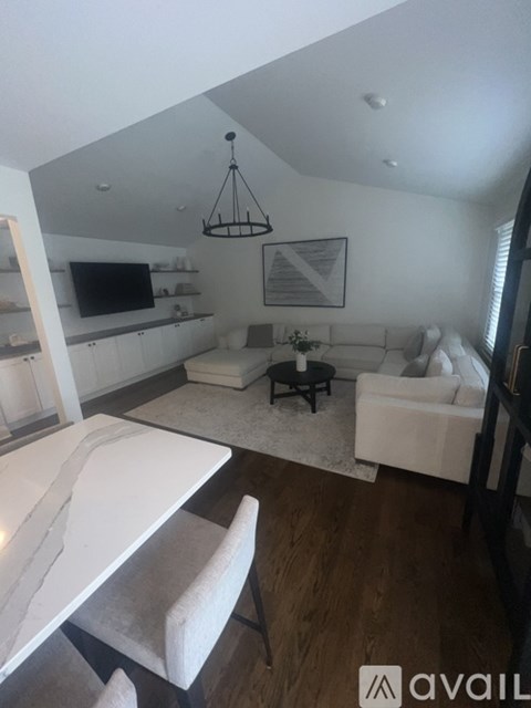 A modern living room with a white sofa and a black coffee table.