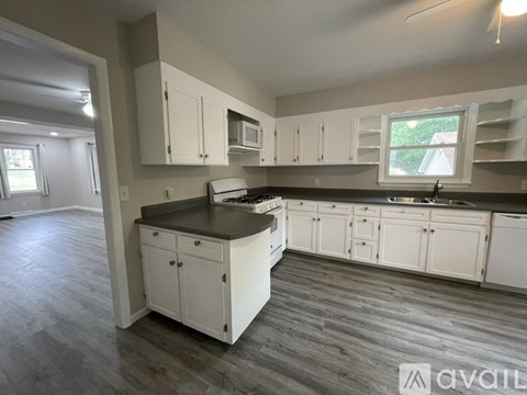 A kitchen with white cabinets and a black countertop.