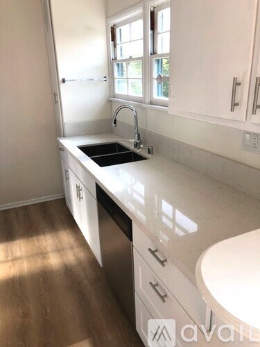 A kitchen with white cabinets and a sink.
